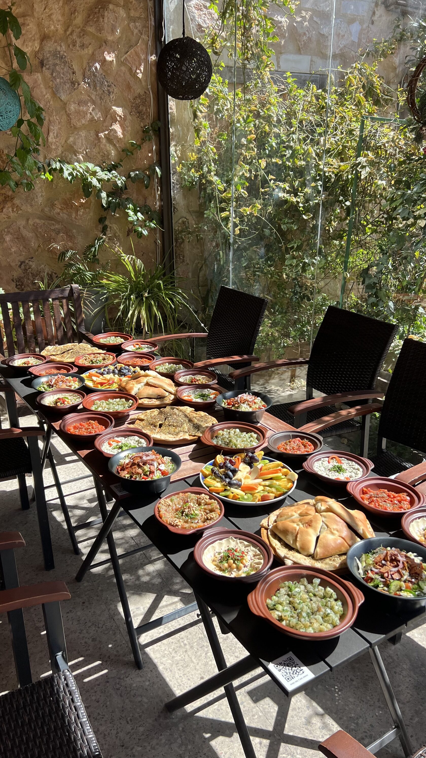 Long table covered with traditional plant-based dishes in clay bowls